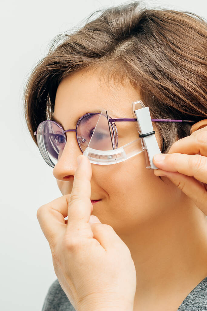 silmälääkäri mittaa silmälasien vanteen erityisellä työkalulla - Valokuva, kuva