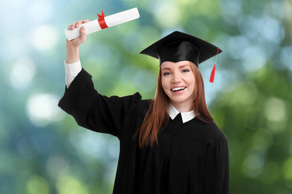 Estudiante feliz con sombrero de graduación y diploma sobre fondo borroso
 - Foto, imagen
