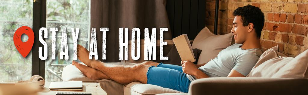 Website-Kopfzeile eines lächelnden Mannes mit gemischter Rasse, der ein Buch auf dem Sofa in der Nähe seines Heimatortes liest  - Foto, Bild