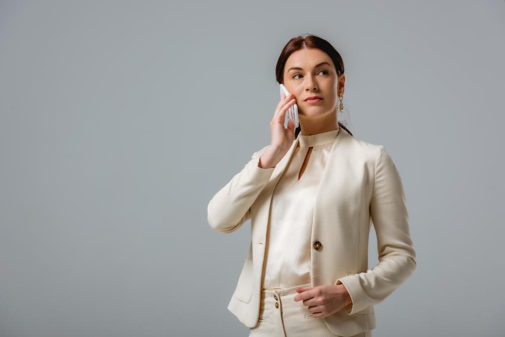 Beautiful businesswoman talking on smartphone isolated on grey  - Photo, Image