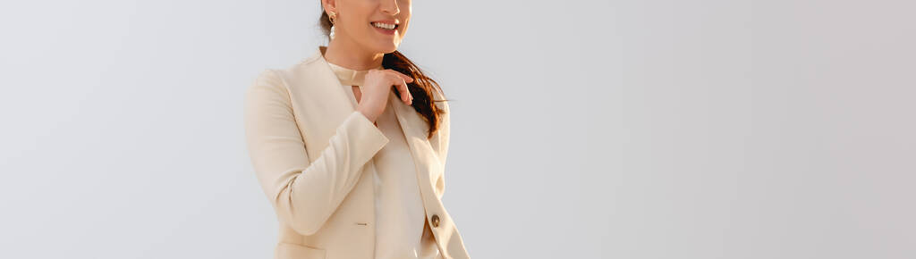 Panoramiczna orientacja pozytywnej bizneswoman uśmiechniętej na szaro  - Zdjęcie, obraz