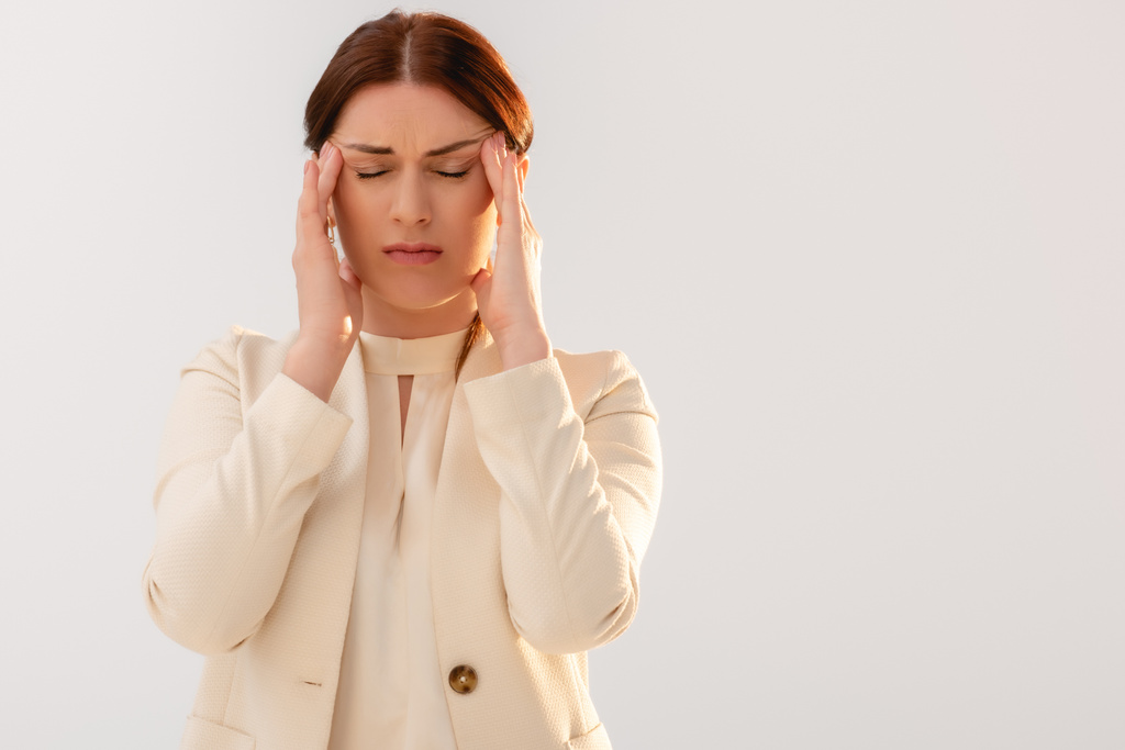 Beautiful businesswoman suffering from migraine isolated on grey  - Photo, Image