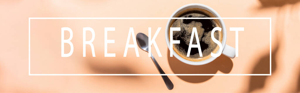 vrchní pohled na šálek kávy a čajovou lžičku na béžové se snídaní nápisy, horizontální koncept  - Fotografie, Obrázek
