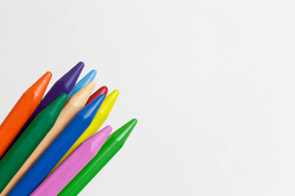 Egy rakás különböző színű viaszzsírkréta ceruza hevert kompozícióban, fehér alapon elszigetelve. Puha pasztell rajz verem. Közelkép, másolás, felülnézet. - Fotó, kép