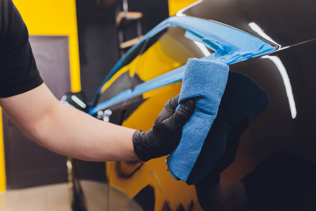 Car detailing - Χέρια με τροχιακό γυαλιστικό σε συνεργείο αυτοκινήτων. Επιλεκτική εστίαση. - Φωτογραφία, εικόνα