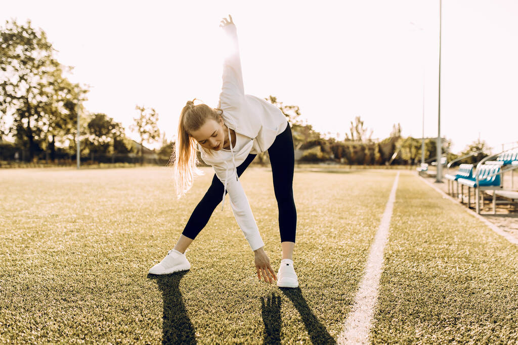 Приваблива струнка атлетична жінка робить вправи на відкритому повітрі. Спорт, коронавірус, карантин
 - Фото, зображення