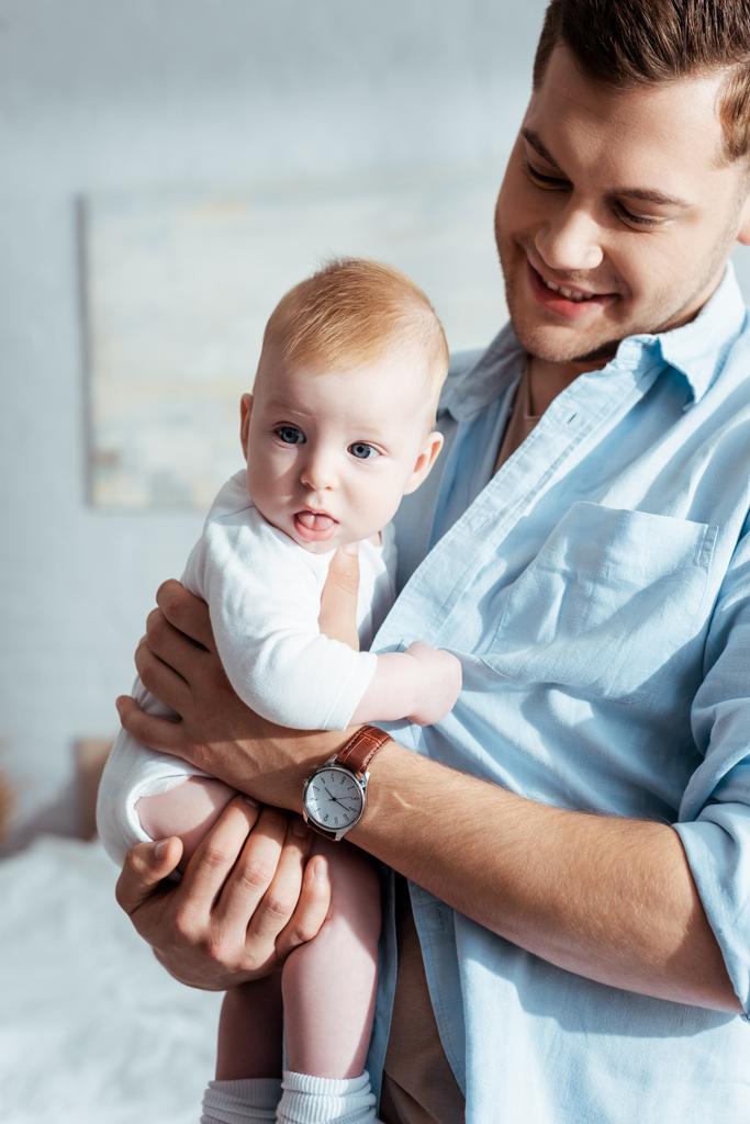 かわいい赤ちゃんの男の子が父親の手に座りながら ロイヤリティフリー写真 画像素材