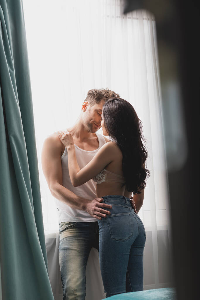 Valikoiva painopiste aistillinen nainen suudella poikaystävä lähellä ikkunaa  - Valokuva, kuva