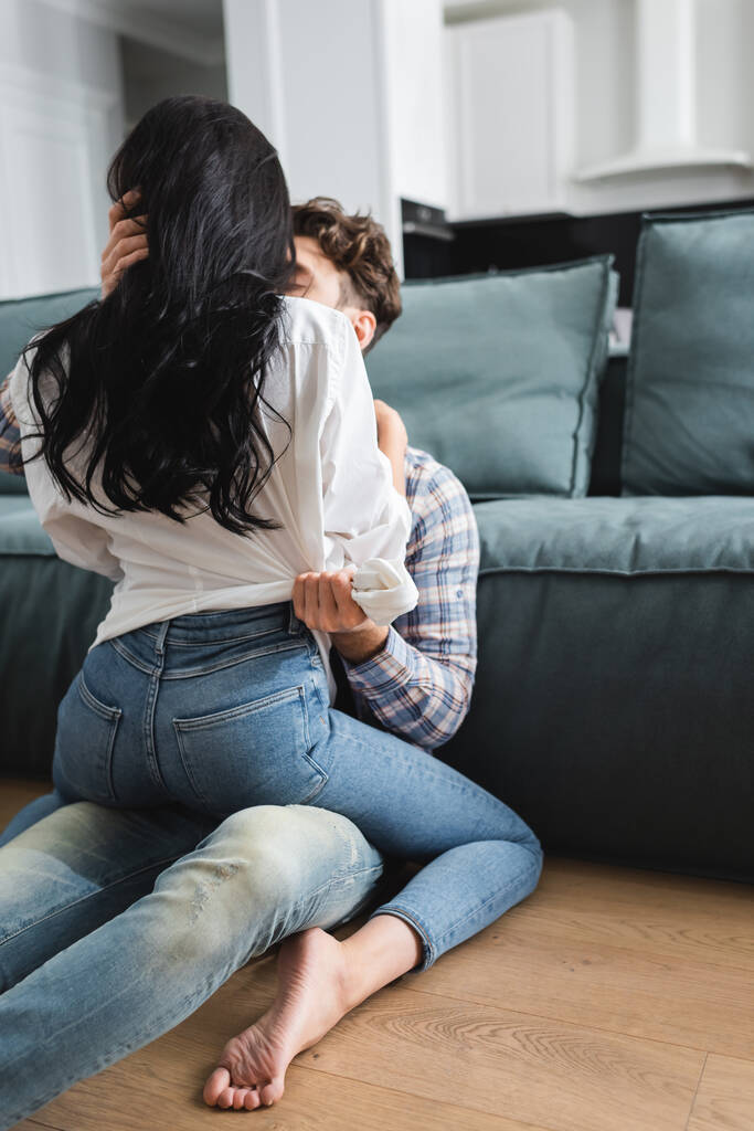 Hombre besando y abrazando sexy novia en el suelo en sala de estar
 - Foto, imagen