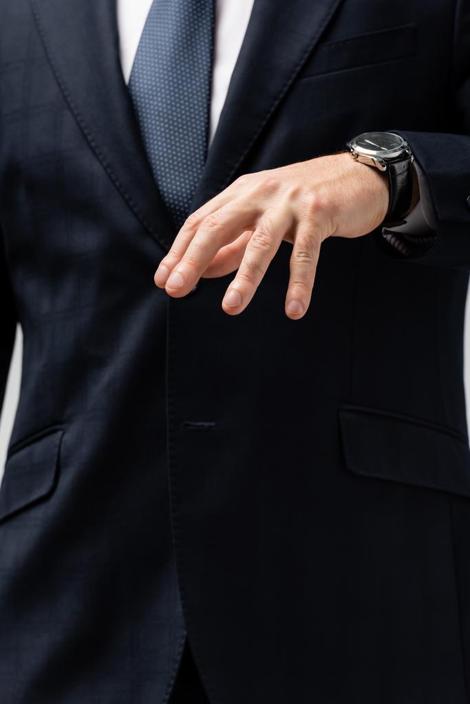 bijgesneden beeld van zakenman in pak manipuleren met de hand geïsoleerd op grijs - Foto, afbeelding