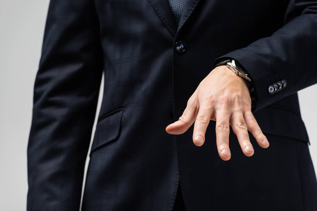 levágott kilátás üzletember öltönyben manipuláló kézzel elszigetelt szürke - Fotó, kép