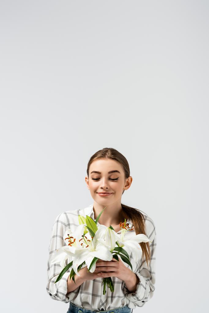 lachend aantrekkelijk meisje poseren als marionet met bloemen geïsoleerd op grijs - Foto, afbeelding