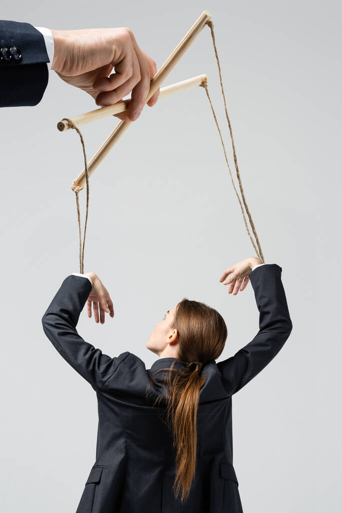 vista recortada del titiritero sosteniendo marioneta empresaria en cuerdas aisladas en gris
 - Foto, Imagen