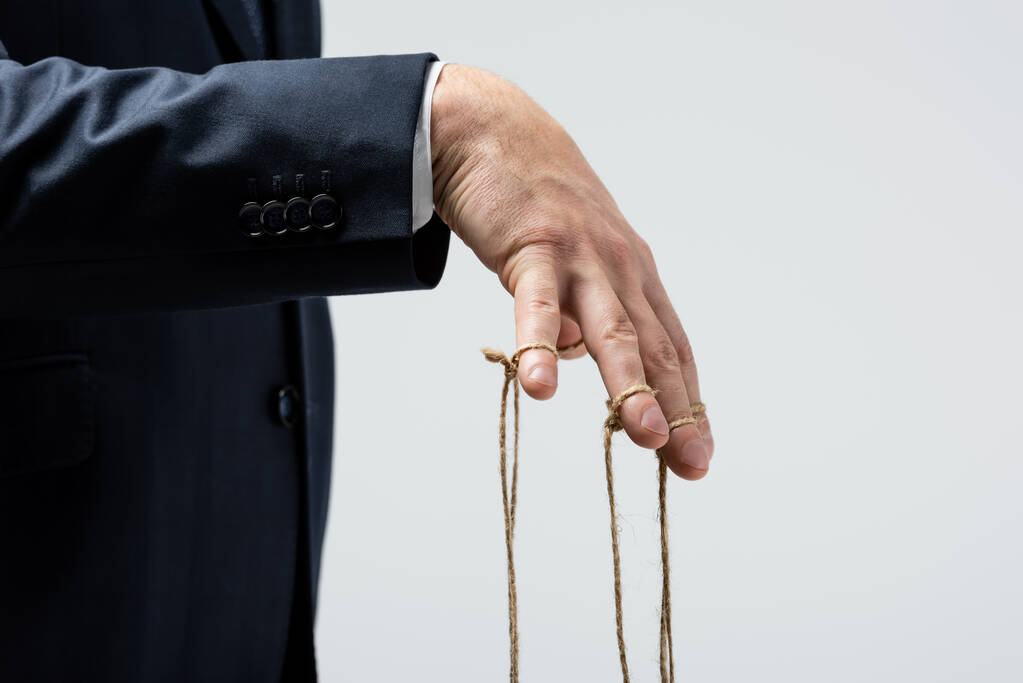 vista recortada de titiritero con cuerdas en los dedos aislados en gris
 - Foto, Imagen