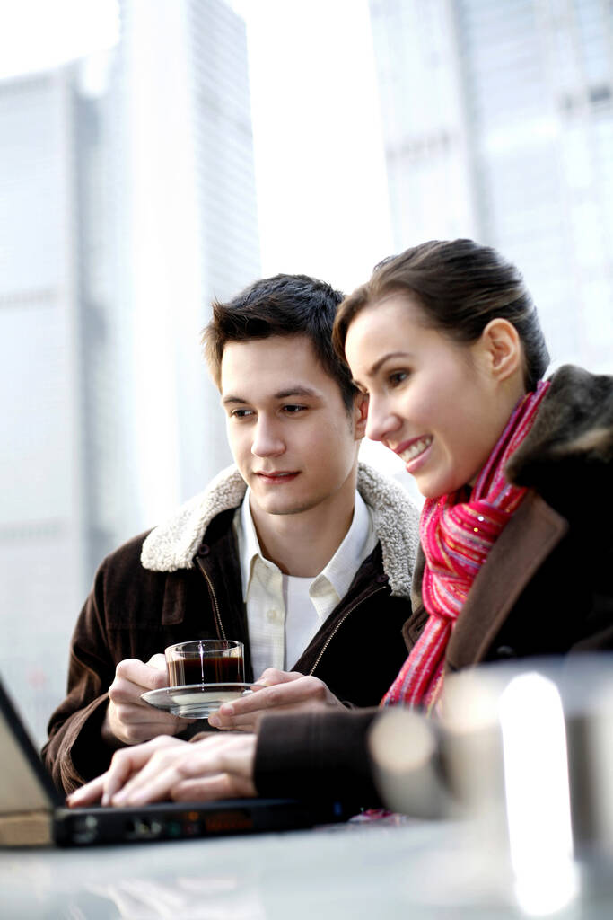 Paar trinkt Kaffee, während es Laptop im Café benutzt - Foto, Bild