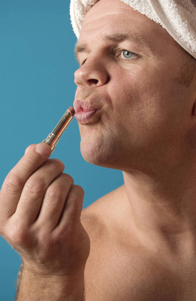 Hombre aplicando lápiz labial en sus labios - Foto, Imagen
