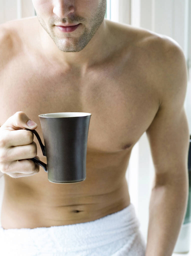 Чоловік з рушником тримає чашку кави
 - Фото, зображення