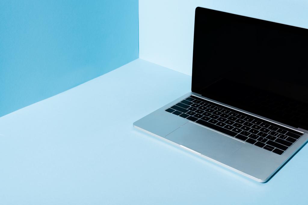 σύγχρονο φορητό υπολογιστή με κενή οθόνη σε μπλε φόντο - Φωτογραφία, εικόνα