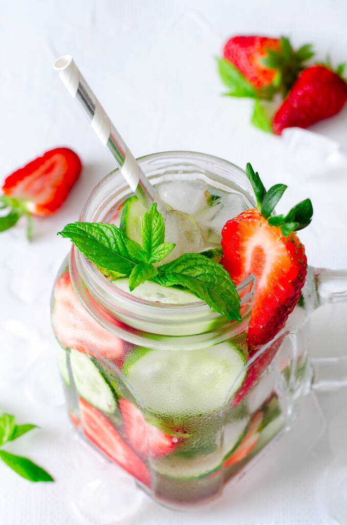 Letní osvěžující ledové nápoje s okurkou a jahodami na bílém pozadí - Fotografie, Obrázek