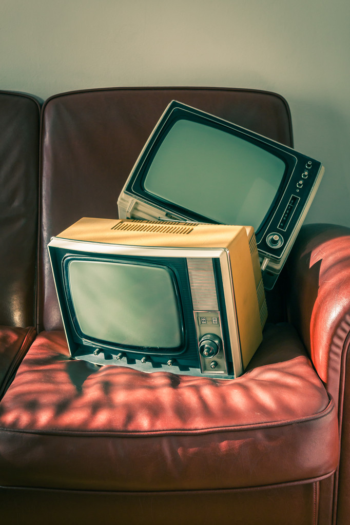 Два старовинні телевізори на червоному дивані
 - Фото, зображення