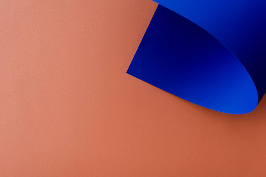 blauw kleurrijk papier op oranje achtergrond - Foto, afbeelding