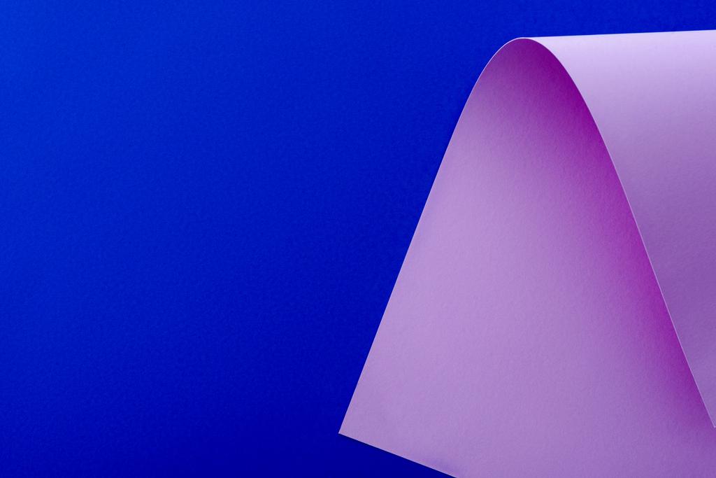 papel lilás curvo sobre fundo azul
 - Foto, Imagem