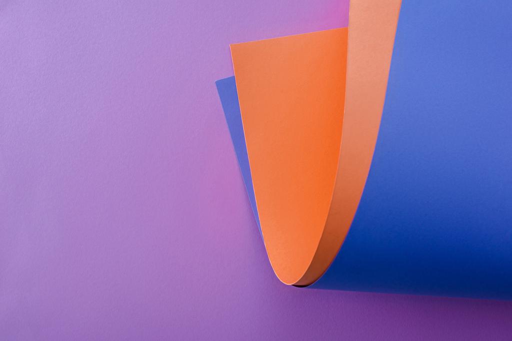 оранжевая и синяя бумага на фиолетовом фоне
 - Фото, изображение