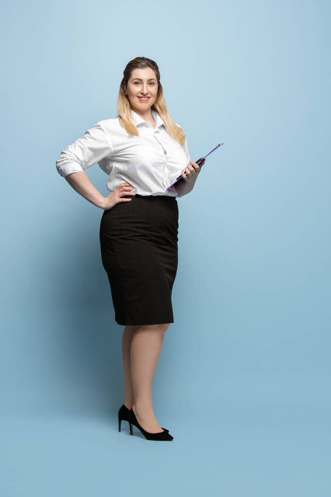 Mavi arka planda, ofisteki beyaz bir kadın. Vücut pozitif kadın karakteri. Artı iş kadını boyutları - Fotoğraf, Görsel