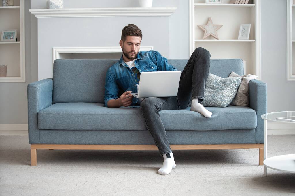 Komea moderni mies suunnittelija työskentelee kannettavan tietokoneen verkossa, internetin avulla kotona - Valokuva, kuva