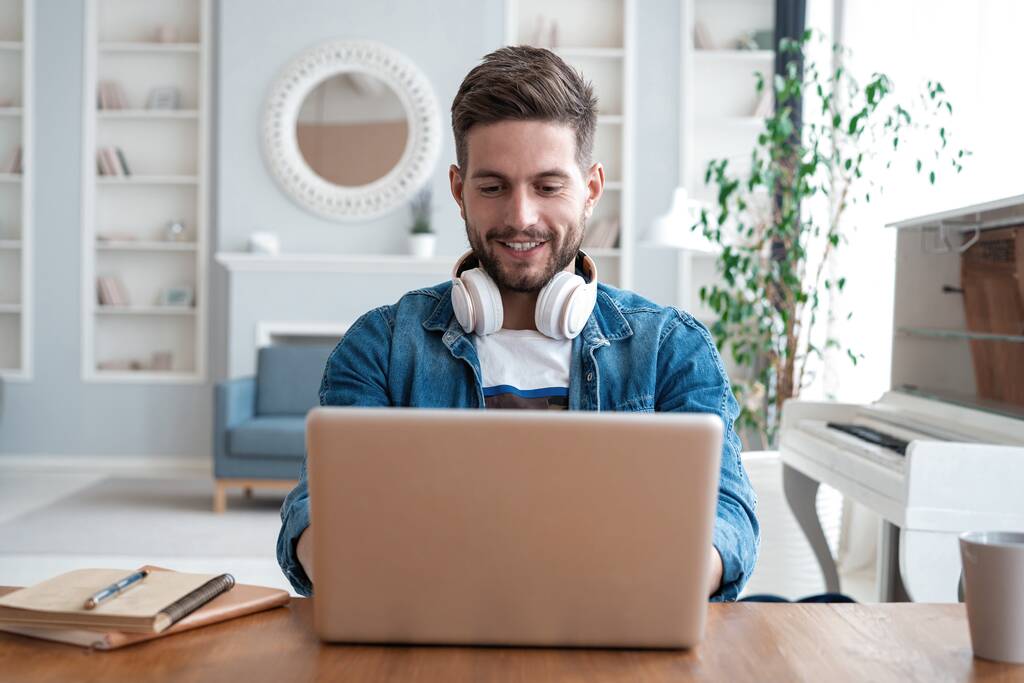Komea moderni mies suunnittelija työskentelee kannettavan tietokoneen verkossa, internetin avulla kotona - Valokuva, kuva
