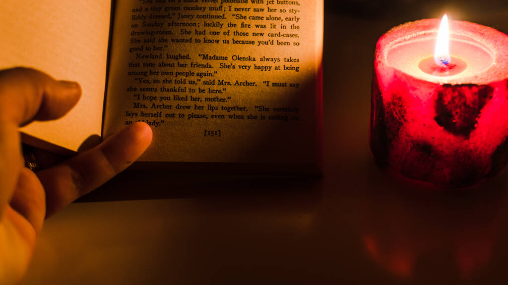 Ein Buch bei Kerzenschein lesen - Foto, Bild