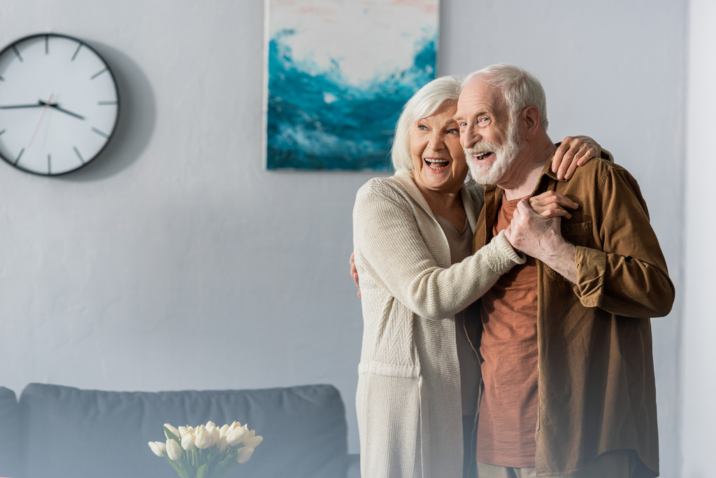 feliz pareja de ancianos bailando en casa y mirando hacia otro lado
 - Foto, imagen