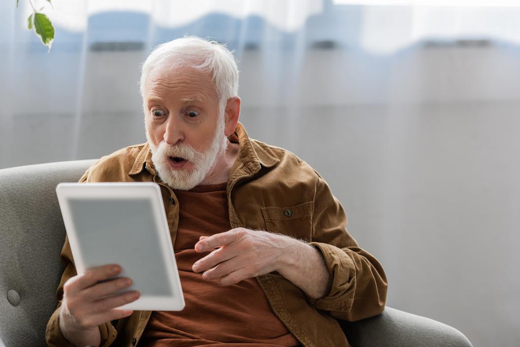 scioccato uomo anziano che punta con il dito durante l'utilizzo di tablet digitale - Foto, immagini