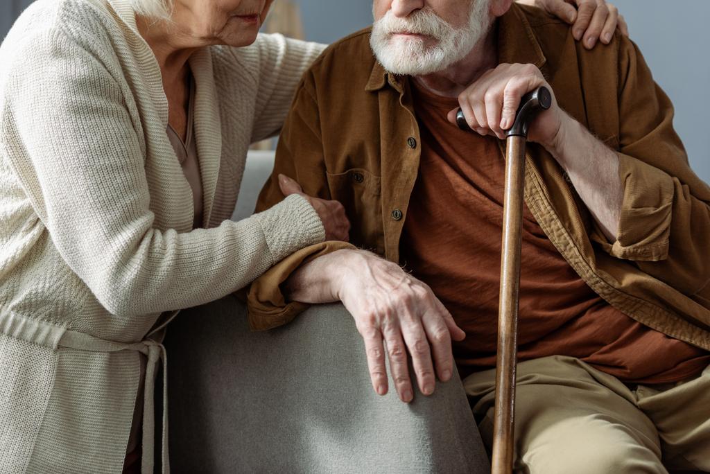 Обрезанный вид пожилой женщины, обнимающей мужа, больной слабоумием
 - Фото, изображение