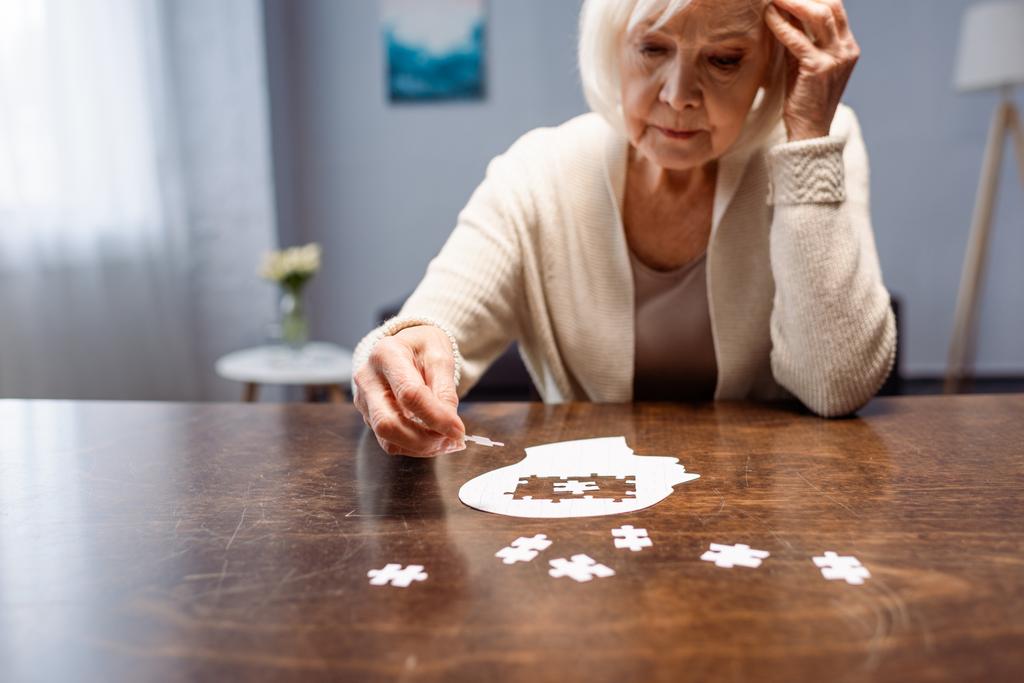 mulher sênior combinando quebra-cabeça para reabilitação de demência
  - Foto, Imagem