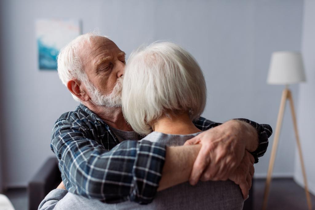 старший чоловік обіймає і цілує дружину, страждає від хвороби Альцгеймера
 - Фото, зображення