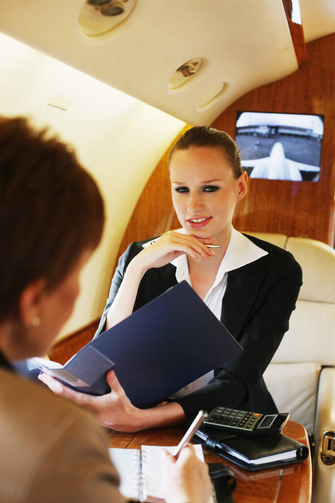 Zakelijke vrouwen in gesprek in prive-jet - Foto, afbeelding