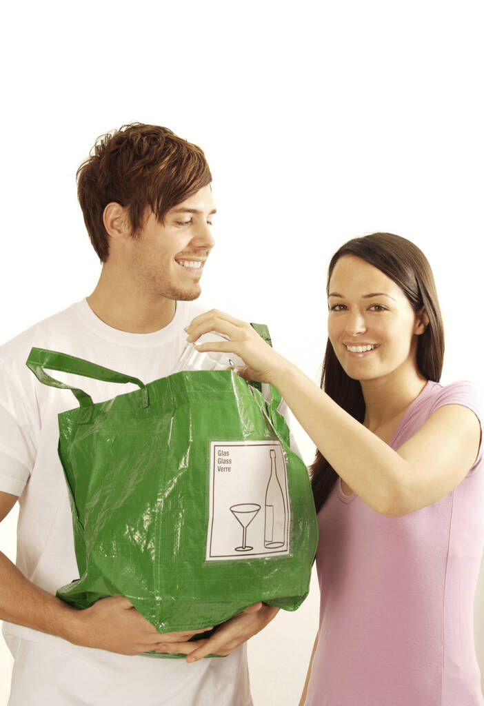 Uomo e donna con sacchetto di vetro e plastica per il riciclaggio - Foto, immagini