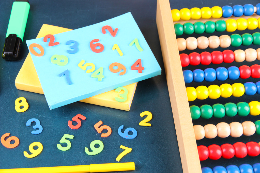 Números coloridos, ábaco, livros e marcadores no fundo da mesa da escola
 - Foto, Imagem