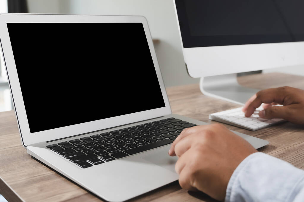 человек бизнеса рука работает на ноутбуке компьютер на деревянном столе ноутбук с чистым экраном на столе
. - Фото, изображение