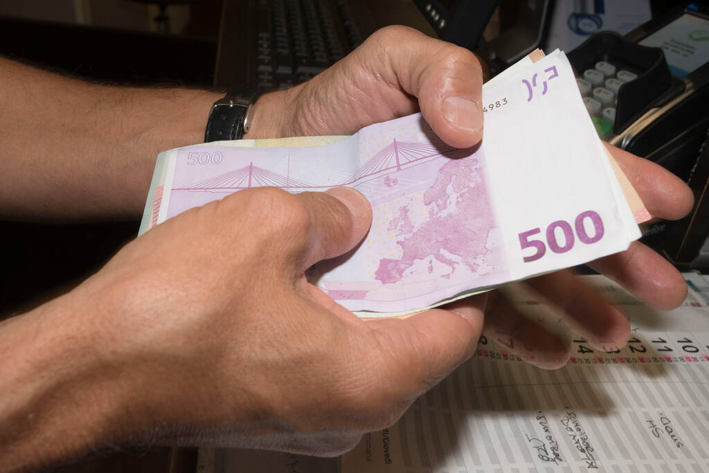 δύο χέρια κρατώντας ένα μάτσο τραπεζογραμμάτια ευρώ, μη αυτόματη καταμέτρηση των χρημάτων - Φωτογραφία, εικόνα