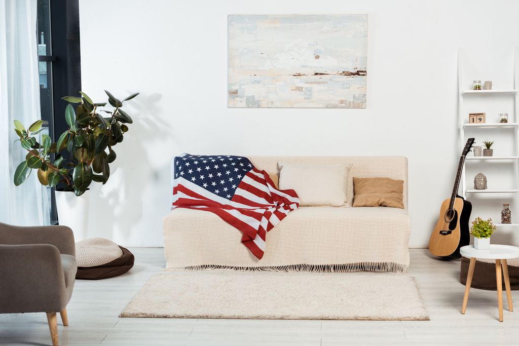 Interior da sala de estar com bandeira americana no sofá
  - Foto, Imagem