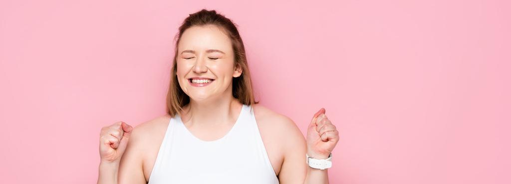οριζόντια εικόνα του ενθουσιασμένοι υπέρβαρο κορίτσι δείχνει νικητής χειρονομία σε ροζ - Φωτογραφία, εικόνα