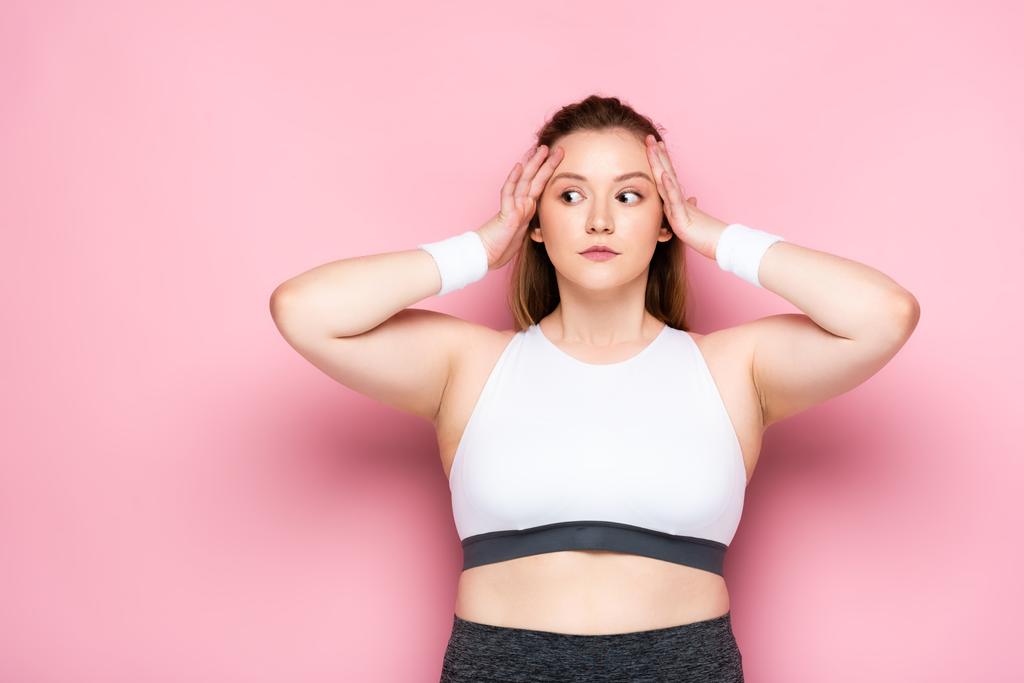 shocked overweight girl touching head and looking away on pink - Photo, Image