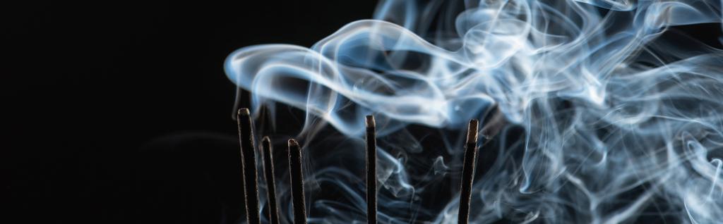 黒い背景に煙で焦げた香りの棒パノラマショット - 写真・画像