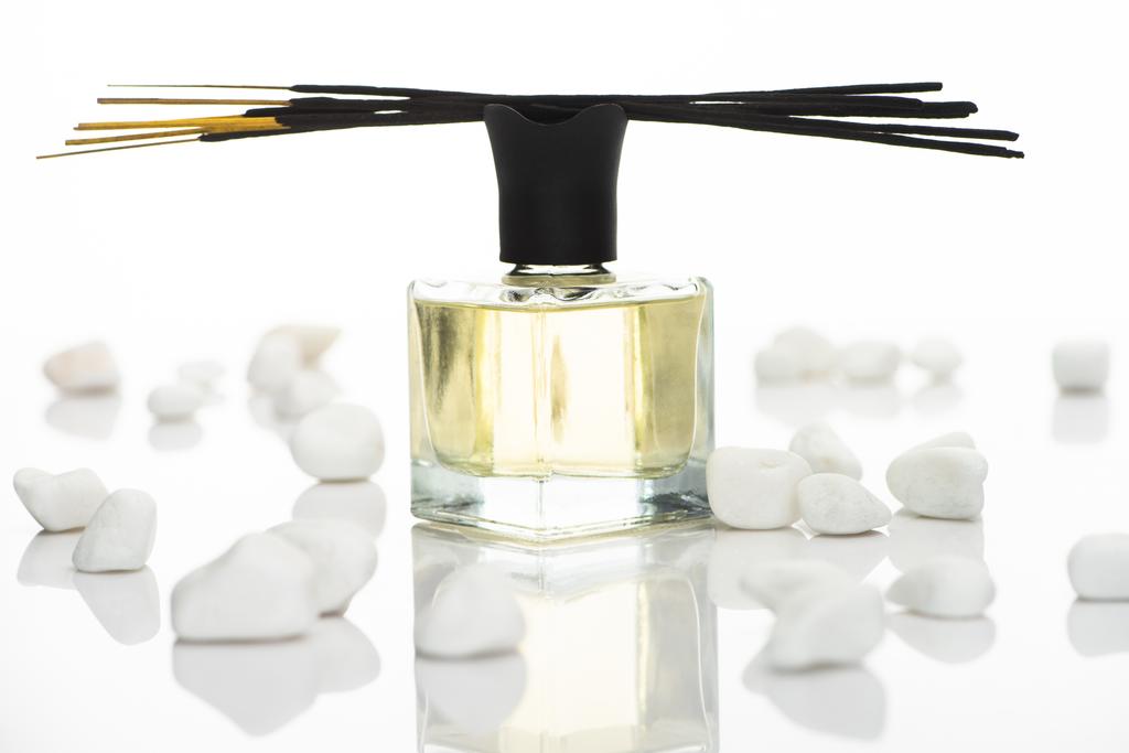 enfoque selectivo de palos de aroma y perfume cerca de piedras aisladas en blanco
 - Foto, Imagen