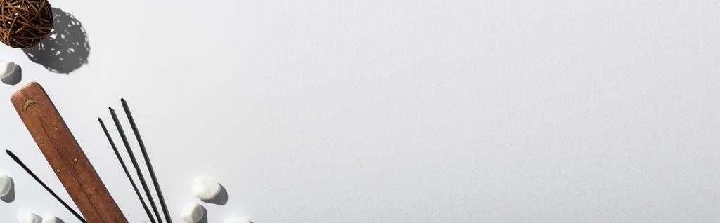 вид сверху на ароматные палочки, камни, стенд и декоративный мяч на белом фоне, панорамный снимок
 - Фото, изображение