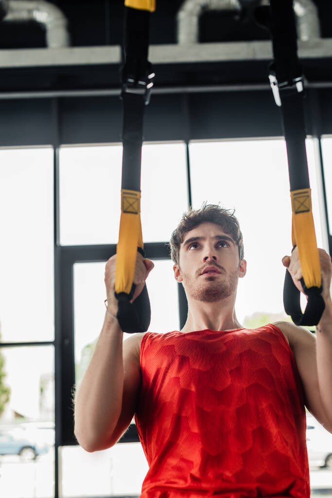 guapo y joven deportista haciendo ejercicio con elásticos en el gimnasio
  - Foto, Imagen