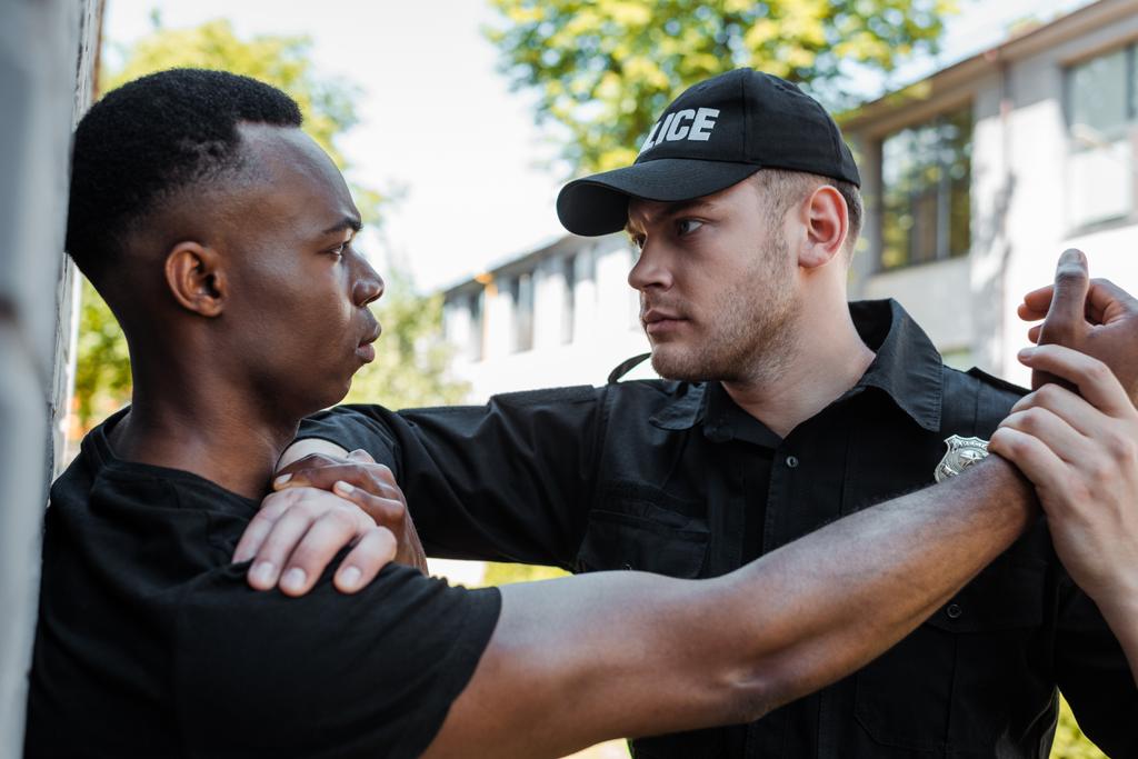 poliziotto in uniforme trattenere l'uomo afro-americano per strada, concetto di razzismo  - Foto, immagini