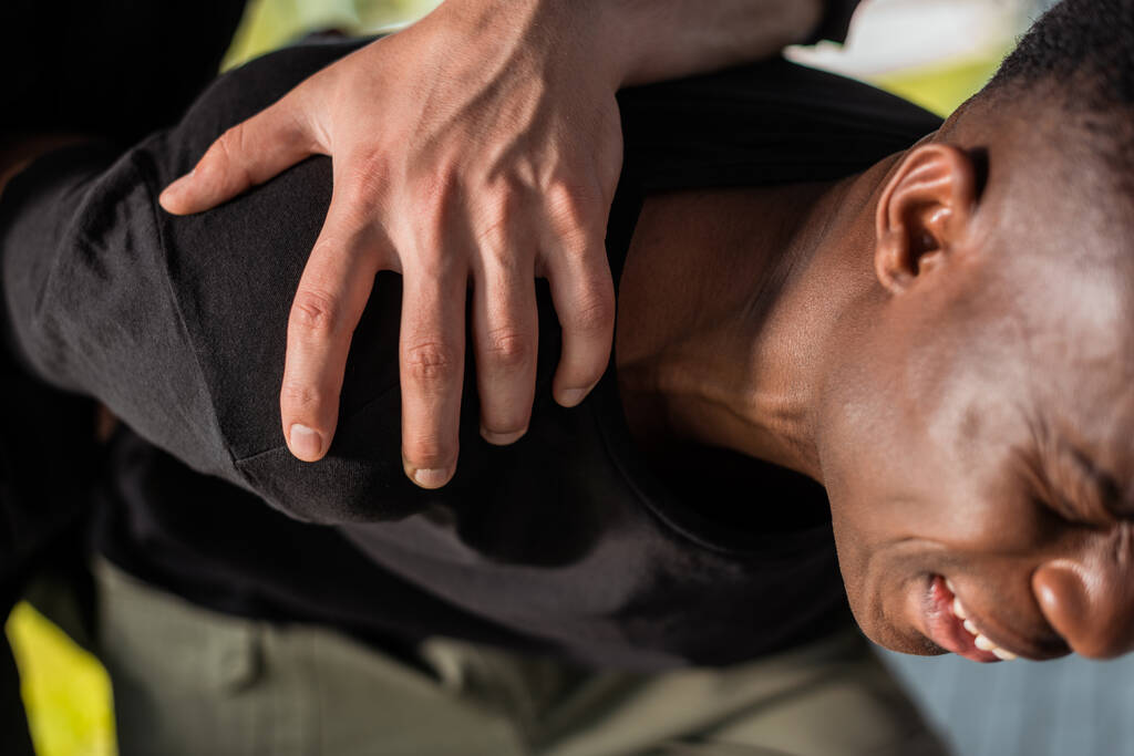 politieagent in hechtenis Afro-Amerikaanse man lijdt aan pijn, racisme concept  - Foto, afbeelding